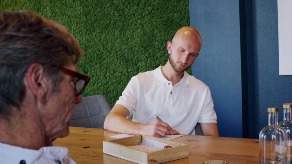 Gesprek tussen twee mensen aan een tafel tijdens een sessie van Beyond Retire